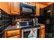 Close-up of kitchen features: wooden cabinets, stainless steel oven, and black countertop at 958 Hillard Ln, Lincolnton, NC 28092
