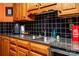 Kitchen features: wood cabinets, black tiled backsplash, and stainless steel sink at 958 Hillard Ln, Lincolnton, NC 28092