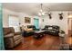Cozy living room featuring hardwood floors, dark leather sofas, and a ceiling fan at 958 Hillard Ln, Lincolnton, NC 28092