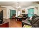 Inviting living room featuring hardwood floors, dark sofas, and bright curtains at 958 Hillard Ln, Lincolnton, NC 28092