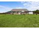 Expansive backyard featuring a well-maintained lawn, wooden fence, and a deck with outdoor seating, perfect for outdoor activities at 100 Royal Ave, Albemarle, NC 28001
