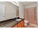 Bathroom featuring a single sink with granite countertop and wood cabinets, with light patterned shower curtains at 1112 Wagner Ave # 335, Fort Mill, SC 29715