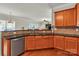 Well-lit kitchen featuring wood cabinets, granite countertops, stainless steel dishwasher, and hardwood floors at 1112 Wagner Ave # 335, Fort Mill, SC 29715