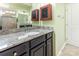 Bathroom featuring a granite countertop, dark wood cabinets, and tiled shower at 1116 Arnott Ln, Matthews, NC 28105