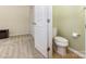 View into a bathroom with a toilet, tile floor and adjacent room with carpeting at 1116 Arnott Ln, Matthews, NC 28105