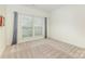 Bright bedroom with neutral carpet, two windows with gray curtains, and ample natural light at 1116 Arnott Ln, Matthews, NC 28105