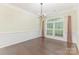 Elegant dining room with hardwood floors, wainscoting, a large window, and stylish chandelier at 1116 Arnott Ln, Matthews, NC 28105