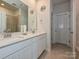 Bathroom features white cabinetry, double sinks, quartz counters, a glass enclosed shower, and tile floors at 11807 Midnight Way, Huntersville, NC 28078
