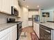 Modern kitchen with granite countertops, stainless steel appliances, and wood-look flooring at 11807 Midnight Way, Huntersville, NC 28078