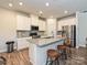 Modern kitchen featuring stainless steel appliances, a granite island, and white cabinetry at 11807 Midnight Way, Huntersville, NC 28078