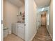 Well-lit laundry area featuring modern appliances and an adjacent hallway leading to additional rooms at 11807 Midnight Way, Huntersville, NC 28078