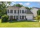 Charming two-story home with black shutters, green lawn, and attached two-car garage on a sunny day at 12250 Wallace Ridge Dr, Charlotte, NC 28269