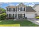 Charming two-story home with black shutters, green lawn, and attached two-car garage on a sunny day at 12250 Wallace Ridge Dr, Charlotte, NC 28269