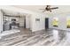 Open-concept living area with modern floors, access to the kitchen, a dark entry door, and lots of natural light at 12250 Wallace Ridge Dr, Charlotte, NC 28269