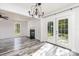 Bright open-concept room featuring French doors, a fireplace, updated floors, and modern lighting fixture at 12250 Wallace Ridge Dr, Charlotte, NC 28269