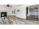 Open living room featuring new floors, a ceiling fan, a fireplace, and access to another room at 12250 Wallace Ridge Dr, Charlotte, NC 28269