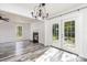 Bright open-concept room featuring French doors, a fireplace, updated floors, and modern lighting fixture at 12250 Wallace Ridge Dr, Charlotte, NC 28269