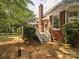 Brick house with a deck, exterior steps, and a natural backyard space with trees at 13101 Kensworth Ct, Charlotte, NC 28277