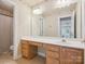 Bright bathroom featuring double sinks and a vanity area, with a view to the bedroom at 13101 Kensworth Ct, Charlotte, NC 28277