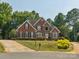 Beautiful two-story brick home with lush landscaping, black shutters and a well manicured lawn at 13101 Kensworth Ct, Charlotte, NC 28277