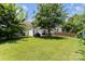 This lush, spacious backyard features a cozy patio area and mature shade trees for outdoor relaxation and enjoyment at 13510 Brandon Trail Dr, Charlotte, NC 28213