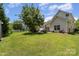 Enjoy a large backyard with a patio seating area, lush lawn, and a mature tree for shade at 13510 Brandon Trail Dr, Charlotte, NC 28213
