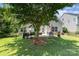 Spacious backyard featuring a patio with dining, lush lawn, mature tree, and partial fence at 13510 Brandon Trail Dr, Charlotte, NC 28213