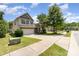 Charming two-story home featuring a two-car garage, green lawn, and lush trees on a sunny day at 13510 Brandon Trail Dr, Charlotte, NC 28213