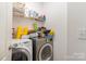 Practical laundry room with washer, dryer, shelving, and ample space for storage at 13510 Brandon Trail Dr, Charlotte, NC 28213