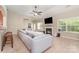 Comfortable living room with a fireplace, large windows, ceiling fan, and a grey sectional sofa at 13510 Brandon Trail Dr, Charlotte, NC 28213