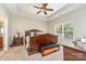 The main bedroom featuring tray ceilings, a large window, and dark wood accents at 13510 Brandon Trail Dr, Charlotte, NC 28213