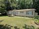 Tan single-story home with a small deck, brown shutters and a large front yard at 1355 Oak Breeze Dr, Mooresville, NC 28115