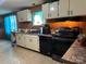 Kitchen with white cabinets, black appliances, wood-look paneling and tile floors at 1355 Oak Breeze Dr, Mooresville, NC 28115