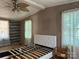 A bedroom showing a headboard, ceiling fan, small windows and a closet at 1355 Oak Breeze Dr, Mooresville, NC 28115