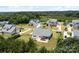 An aerial view of a home with an outdoor kitchen, patio, firepit, mature trees, and a fenced-in yard at 152 Riverstone Dr, Davidson, NC 28036