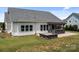 The backyard boasts an outdoor kitchen, stone patio, fire pit, manicured lawn and fenced-in perimeter at 152 Riverstone Dr, Davidson, NC 28036