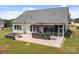 This backyard offers a stone-paved patio, outdoor kitchen, fire pit, screened porch and manicured lawn at 152 Riverstone Dr, Davidson, NC 28036