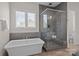 Modern bathroom showcasing a freestanding tub and walk-in shower with gray tiling and a built-in bench at 152 Riverstone Dr, Davidson, NC 28036