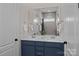 Modern bathroom featuring double sinks, blue vanity, and a large mirror at 152 Riverstone Dr, Davidson, NC 28036