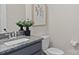 Stylish half bath with granite countertop, gray cabinets, a round mirror, and toilet at 152 Riverstone Dr, Davidson, NC 28036
