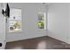 Bright bedroom with dark wood floors, two windows offering views, and a wall-mounted television at 152 Riverstone Dr, Davidson, NC 28036