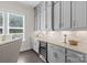 A butler's pantry has grey cabinets, lots of counter space, a wine cooler and tile backsplash at 152 Riverstone Dr, Davidson, NC 28036