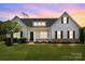 Charming home with black shutters, dormer windows, black front door, manicured lawn and front garden at 152 Riverstone Dr, Davidson, NC 28036