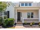 Inviting front porch with white railing, black front door, and tidy landscaping at 152 Riverstone Dr, Davidson, NC 28036