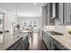 Modern kitchen design showcasing gray cabinets, an island with a sink, and a view to the dining area at 152 Riverstone Dr, Davidson, NC 28036