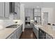 Galley kitchen with gray cabinets, stainless steel appliances, and quartz countertops at 152 Riverstone Dr, Davidson, NC 28036
