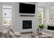 This living room features a fireplace, hardwood floors, large windows, neutral decor, and tv at 152 Riverstone Dr, Davidson, NC 28036