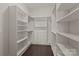 This walk-in closet features built-in shelving and drawers with ample storage solutions and dark wood floors at 152 Riverstone Dr, Davidson, NC 28036