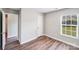 Cozy bedroom with wood-look floors and neutral walls featuring a window allowing natural light at 1703 Southwind Dr, Charlotte, NC 28216
