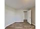 A minimalist bedroom featuring hardwood flooring and a neutral color palette, offering a tranquil and inviting atmosphere at 1703 Southwind Dr, Charlotte, NC 28216